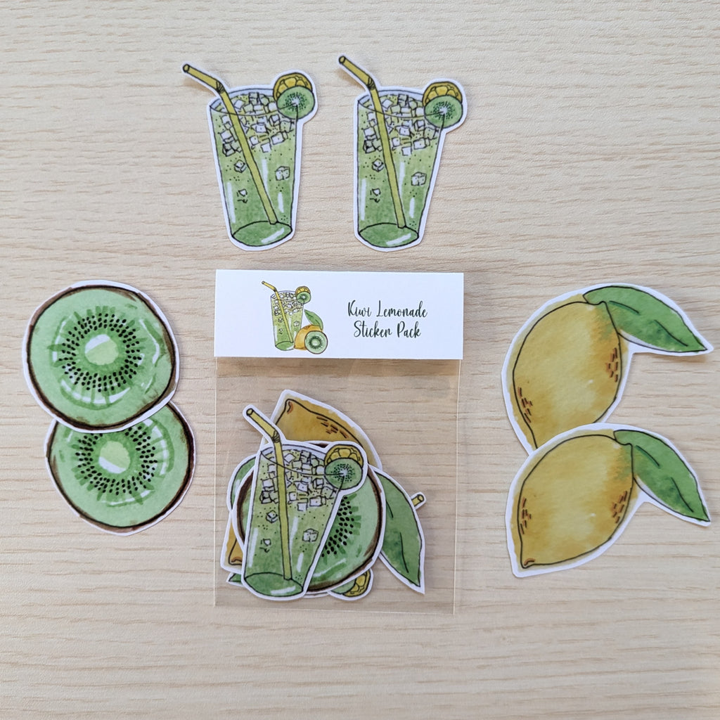 A sticker pack featuring watercolor-style illustrations of green kiwi slices, yellow lemons, and two green lemonade glasses with straws, arranged on a light wood surface with a small brand card reading 'Kiwi Lemonade Sticker Pack'.